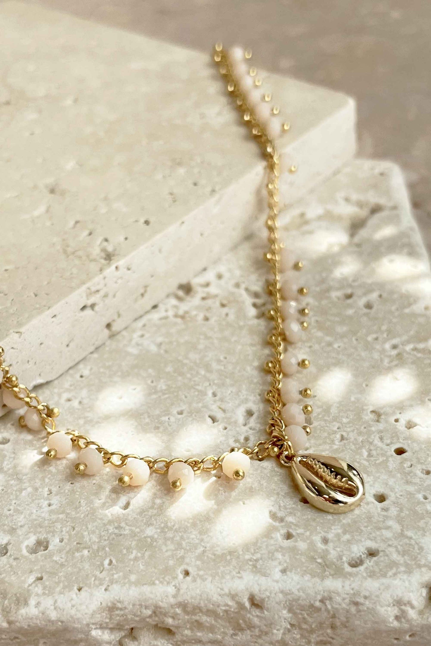 GOLD-BEADED-NECKLACE-COWRIE-SHELL-FLAT-LAY-CLOSE