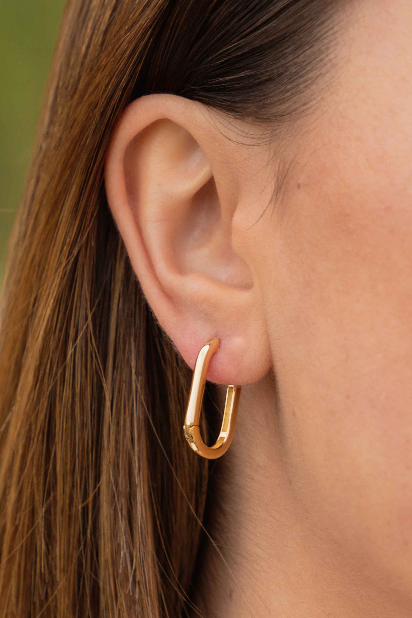 sleek-contemporary-gold-oval-hoops-on-body-close